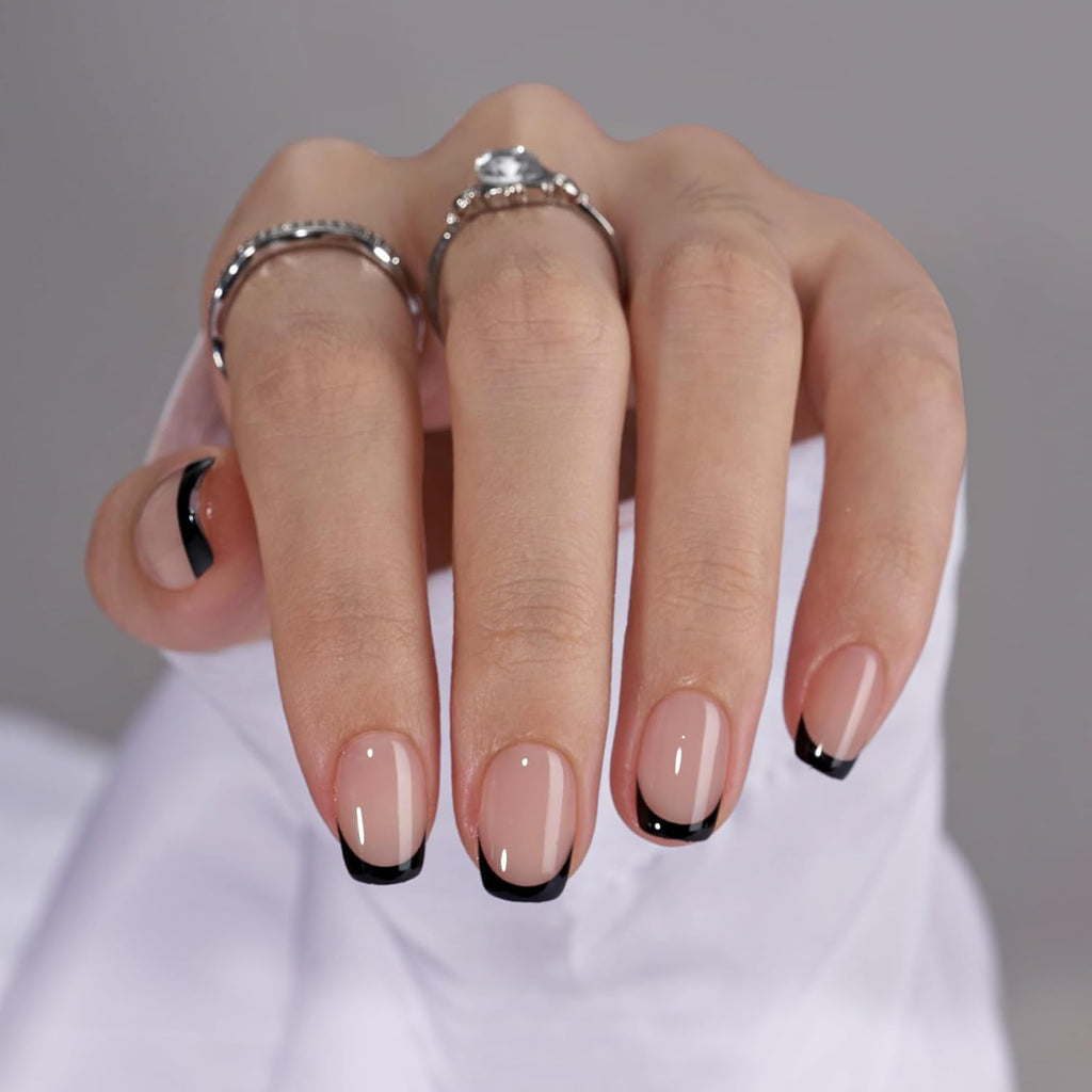 Hand wearing black French tip press-on nails short square shape