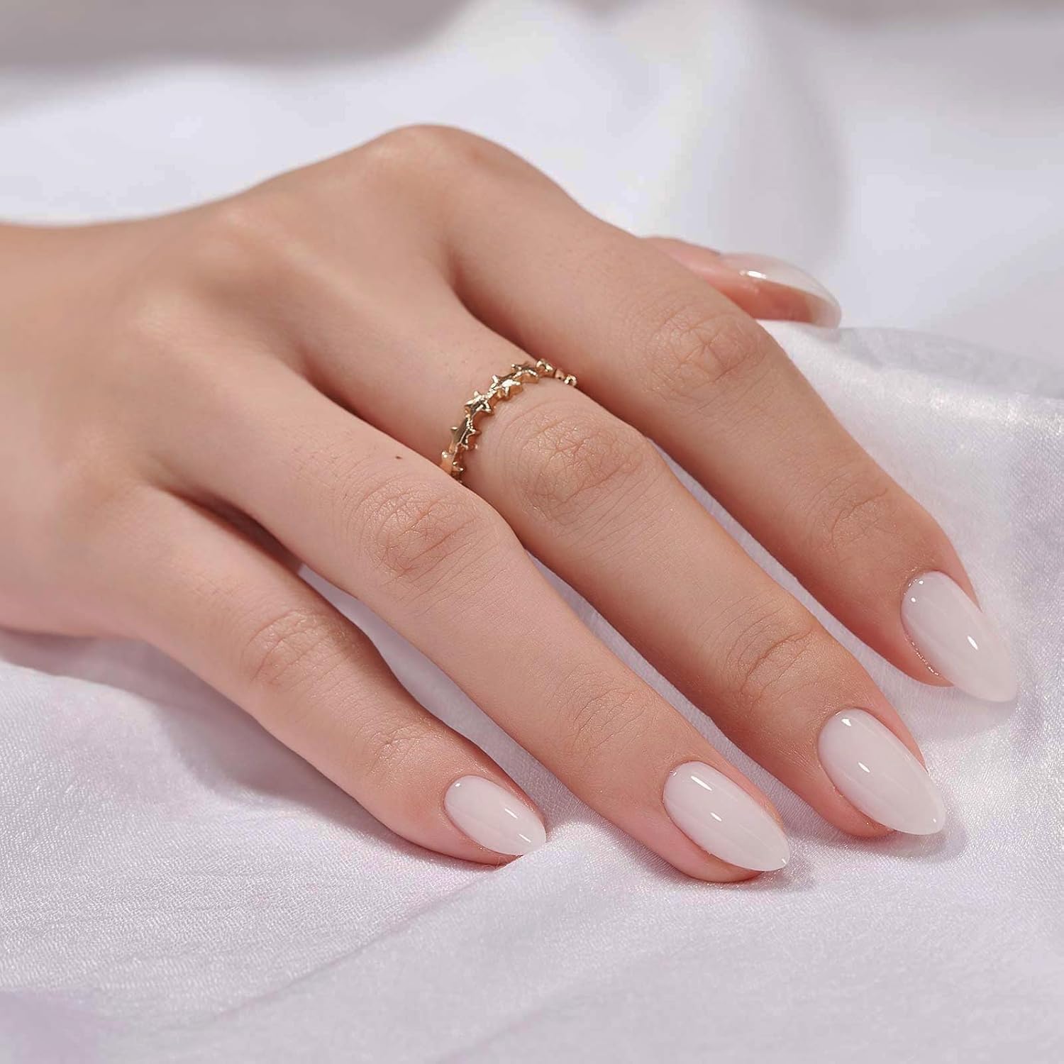 Hand wearing short almond white press-on nails with glossy gel finish